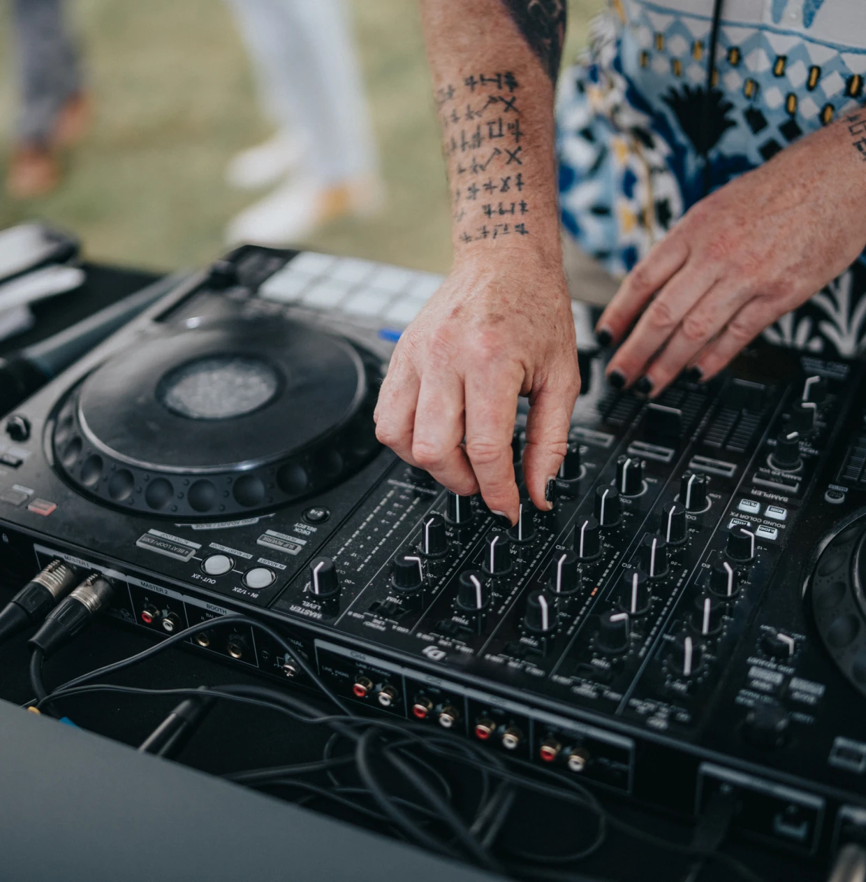 DJ adjusting mixer controls at event